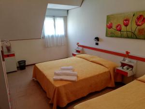 sypialnia z 2 łóżkami i obrazem na ścianie w obiekcie Hotel Devon Rooms & Breakfast w Cesenatico +37 zdjęć
