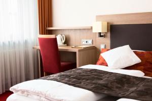 a hotel room with a bed and a desk at Hotel Weisses Ross in Memmingen
