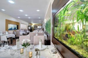 ein Restaurant mit Tischen und Stühlen und einem Aquarium in der Unterkunft Dixon Resort & Wellness in Banská Bystrica