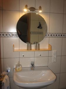 baño con lavabo y espejo en la pared en Gästehaus Proisl en Lenggries