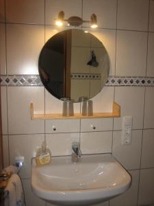a bathroom with a sink and a mirror on the wall at Gästehaus Proisl in Lenggries