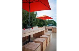 a picnic table with a red umbrella and benches at Bed in Boat in Ieper