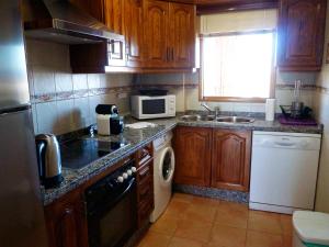 - une petite cuisine avec des placards en bois et un four micro-ondes dans l'établissement Jabeque, à Estepona