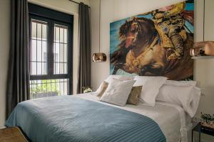 een slaapkamer met een bed met een schilderij van een paard bij Matahacas Pool & Luxury in Sevilla +106 foto's