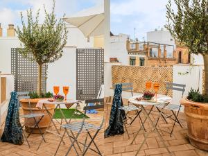un patio con mesas y sillas en la azotea en Matahacas Pool & Luxury, en Sevilla