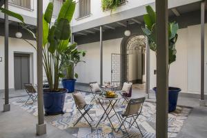 een kamer met stoelen, een tafel en potplanten bij Matahacas Pool & Luxury in Sevilla