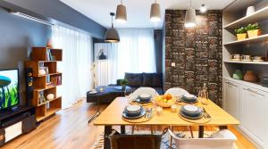 a living room with a dining table and a television at Stylish and High-end Designer Apartments in City Center in Sofia