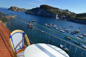 einen Tisch und Stühle auf einem Balkon mit Blick auf den Hafen in der Unterkunft Maridea - Donatino a Mare in Ponza