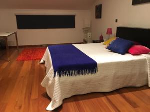 1 dormitorio con 1 cama con almohadas y TV de pantalla plana en Terra Mar, en Ponta Delgada