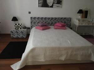 1 dormitorio con 1 cama blanca grande con almohadas rosas en Terra Mar, en Ponta Delgada