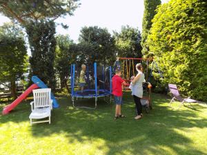 Ein Mann und eine Frau spielen auf einem Spielplatz in der Unterkunft Pensjonat Angela in Łeba