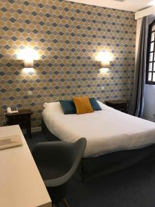 une chambre d'hôtel avec un lit et une chaise dans l'établissement Hôtel De La Loge, à Perpignan