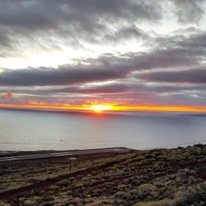 un tramonto sull'oceano con il sole nel cielo di Vivienda Vacacional Monteprimero 2 a Tamaduste