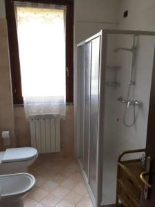 ein Bad mit einem WC, einer Dusche und einem Fenster in der Unterkunft Casa Girasole in Fino Mornasco