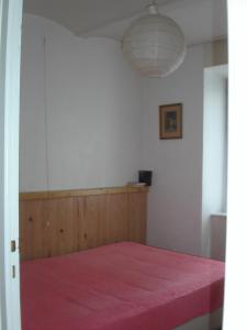 una camera con un letto con una coperta rossa di Gite Deux-Eaux a Saint-Martial