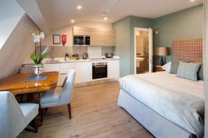 a bedroom with a bed and a table and a kitchen at Beech House - Urban Apartments in Bristol +40 photos