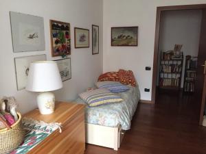 ein Schlafzimmer mit einem Bett und einem Tisch mit einer Lampe in der Unterkunft Casa Girasole in Fino Mornasco