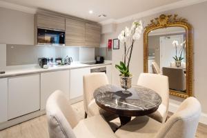 a kitchen and dining room with a table and chairs at Beech House - Urban Apartments in Bristol
