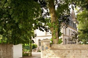 a white house with a tree in front of it at Château de la Marine in Wimille