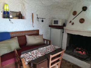 a living room with a couch and a fireplace at Cueva El Madrono in Pegalajar