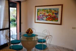 a dining room with a glass table and chairs at Villa Flamingo in Villasimius