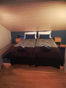 a bedroom with a large bed with two pillows at Koskentien kotimajoitus & Luxury Glamping in Jämsä