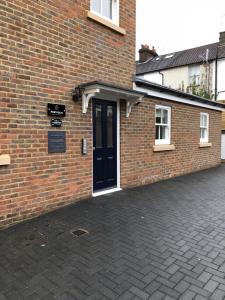 Portfolio Apartments - St Albans City Centre في سانت ألبانز: مبنى من الطوب مع باب أسود وممر