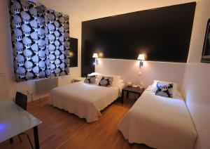 トゥールにあるホテル イタリアのベッド2台と大きな窓が備わるホテルルームです。