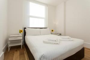 a bedroom with a bed with two towels on it at Gorgeous 2 bed flat near Central London for 6 in London