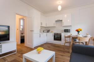 a kitchen and living room with a couch and a table at Gorgeous 2 bed flat near Central London for 6 in London
