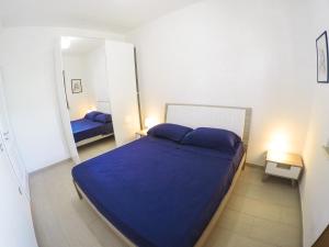 ein Schlafzimmer mit einem blauen Bett und einem Spiegel in der Unterkunft Villa di Lusso sul Mare a Diamante - Villa Ventre in Belvedere Marittimo