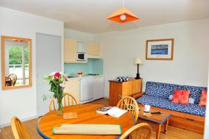 een woonkamer met een bank en een tafel bij Goélia Résidence du Golf de l'Océan in Carantec