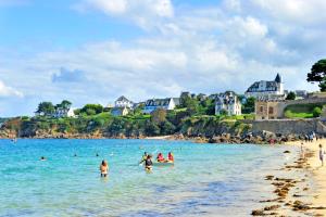 un grupo de personas en el agua en una playa en Goélia Résidence du Golf de l'Océan en Carantec