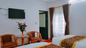 薩帕的住宿－Fancy Sapa Hostel 2，一间酒店客房,设有两张床、一张桌子和一台电视机