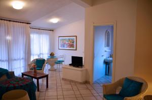 a living room with a couch and a table and a television at Villa Flamingo in Villasimius