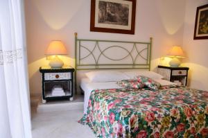 a bedroom with a bed and two night stands with lamps at Villa Flamingo in Villasimius
