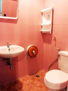 One One Hostel Patong في شاطيء باتونغ: حمام وردي مع مرحاض ومغسلة