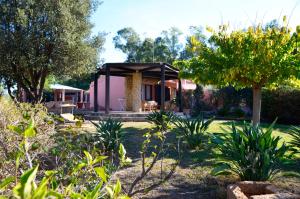 a house with a pavilion in a garden at Villa Flamingo in Villasimius