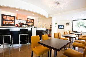 ein Restaurant mit Tischen und Stühlen und eine Bar in der Unterkunft Hotel Apollo in Cesenatico