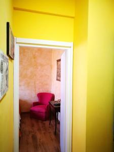 ラパッロにあるLa Caravella apartamentの赤い椅子とテーブルが備わる客室です。