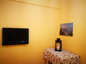 a flat screen tv hanging on a wall with a table at La Caravella apartament in Rapallo