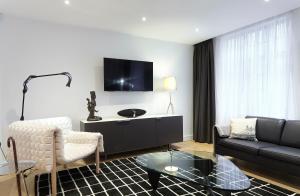 a living room with a couch and a tv at Veeve - Marylebone Mews in London