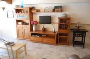 een woonkamer met een tv en houten meubilair bij Apartment Fuentes de Nerja in Nerja