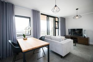 ein Wohnzimmer mit einem Sofa und einem Tisch in der Unterkunft Waters Edge Self-Catering Apartment in Kapstadt