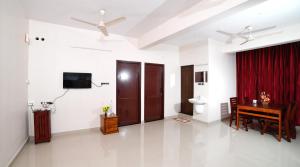 a living room with a desk and a red curtain at Indeevaram Residency in Trivandrum