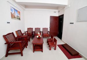 a room with chairs and a table with flowers on it at Indeevaram Residency in Trivandrum