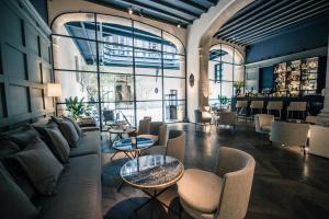 a living room with couches and tables and chairs at Sant Francesc Hotel Singular in Palma de Mallorca