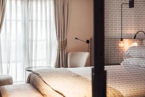 a bedroom with a bed and a table and a window at Sant Francesc Hotel Singular in Palma de Mallorca