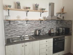 a kitchen with a sink and a brick wall at Anastasia Studios, Apartments & Suites in Archangelos