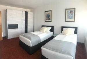 2 Betten in einem Hotelzimmer mit in der Unterkunft Gästehaus beim Prinz in Kürten